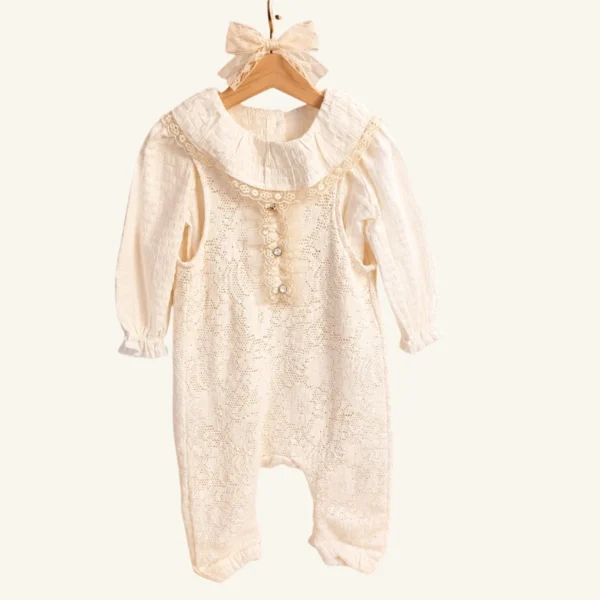 Ivory baby romper with delicate lace and a wide collar.